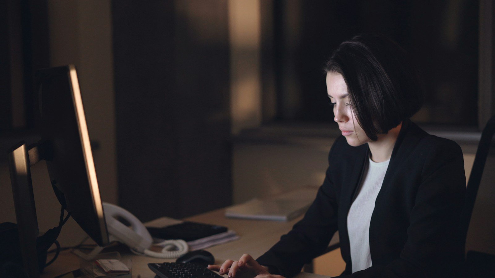 Professional working late while planning how to manage graduate school with unpredictable overtime